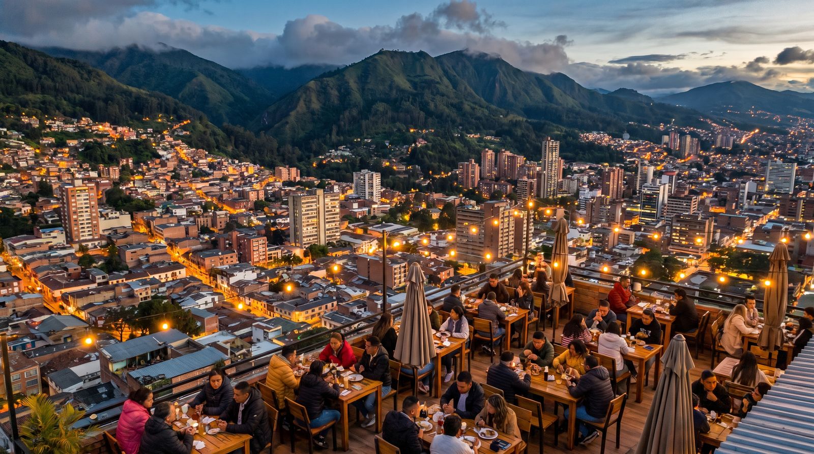 Ciudad colombiana entre montañas al anochecer, con una terraza en primer plano
